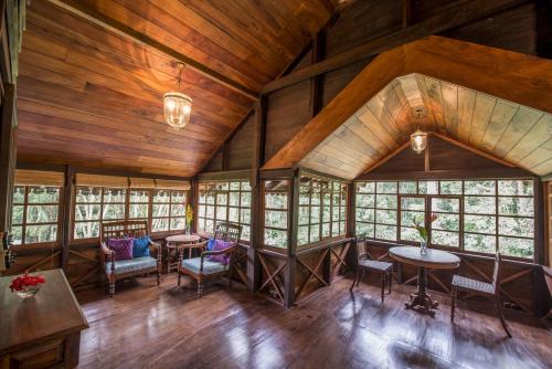 a large room with wooden ceilings and tables and chairs at Pepper Trail in Sultan Bathery