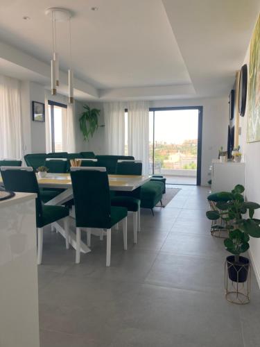 una sala da pranzo con tavolo e sedie verdi di Luxury Apartment Agnieto - The View Fuengirola a Fuengirola