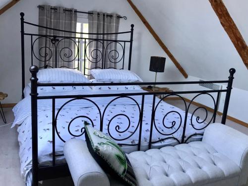 ein schwarzes Metallbett mit einer Couch in einem Zimmer in der Unterkunft Sea Breeze Cottage in Eisma