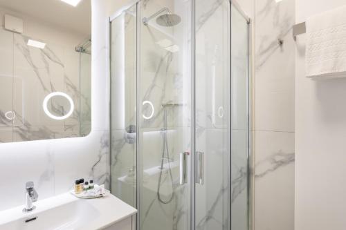 a white bathroom with a shower and a sink at Hotel Aquila D'Oro Desenzano in Desenzano del Garda