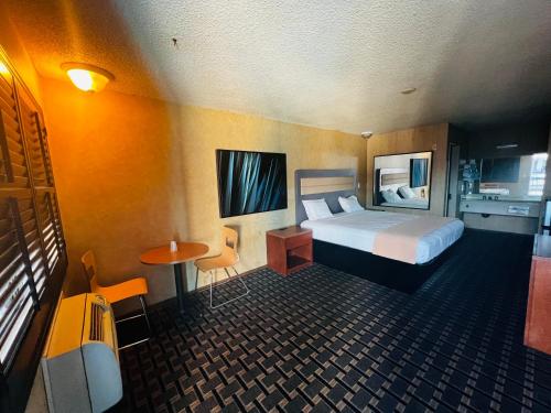 una camera d'albergo con letto e tavolino di Casa Playa Inn & Suites Stanton Anaheim Area a Stanton