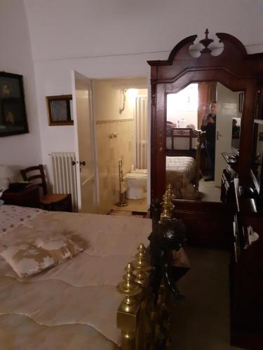 um quarto com uma cama e um espelho e um homem de pé na casa de banho em Appartamento in palazzo nobiliare em Nardò