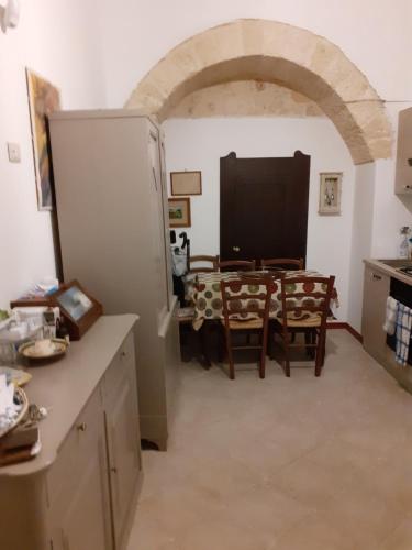 uma cozinha e sala de jantar com mesa e cadeiras em Appartamento in palazzo nobiliare em Nardò