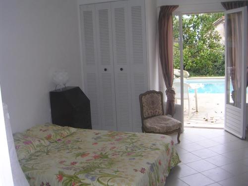 ein Schlafzimmer mit einem Bett, einem Stuhl und einem Pool in der Unterkunft Très jolie villa à Vence in Vence