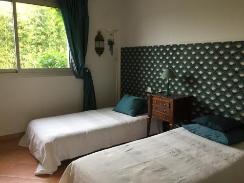 1 Schlafzimmer mit 2 Betten und einem Fenster in der Unterkunft Très jolie villa à Vence in Vence