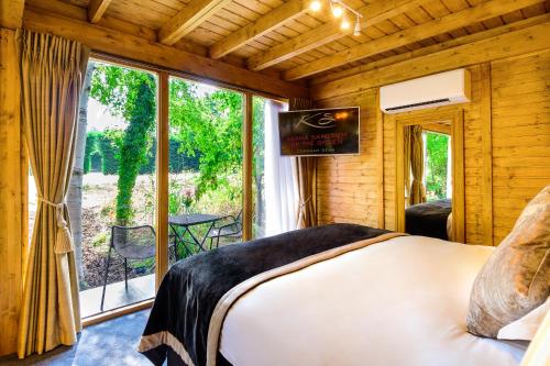sypialnia z łóżkiem i dużym oknem w obiekcie Sanctum On The Green Hotel w mieście Cookham Dean