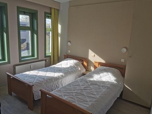 2 camas en una habitación con 2 ventanas en APPARTEMENT WESTENDE (DRIEMASTER), en Middelkerke