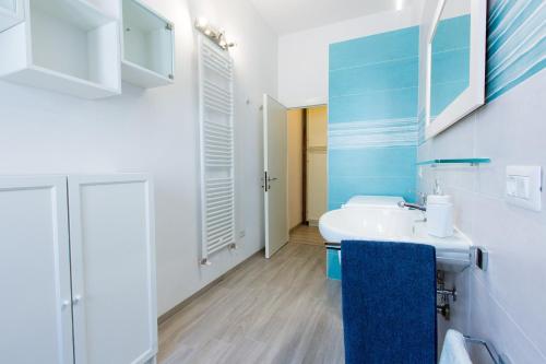 een badkamer met een witte wastafel en een blauwe handdoek bij San Giovanni in San Gimignano
