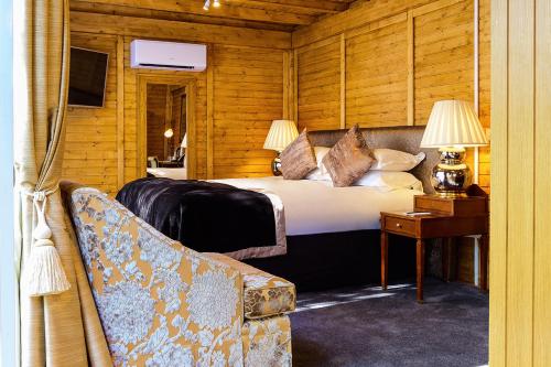a bedroom with a bed and a table and a couch at The Inn On The Green in Cookham Dean
