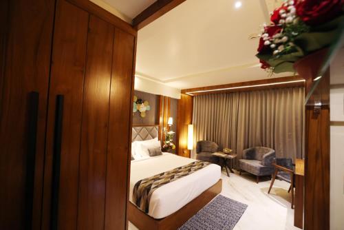 a hotel room with a bed and a desk at AJ Grand Hotel in Mangalore