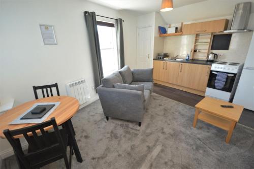 a kitchen and living room with a table and a couch at Buzzard Apartment in Tobermory