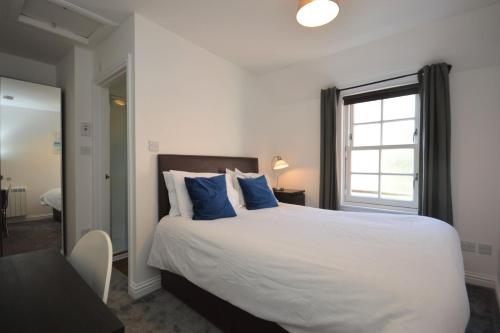 a bedroom with a large white bed with blue pillows at Buzzard Apartment in Tobermory
