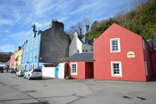 a red building with a bird on top of it at Buzzard Apartment in Tobermory