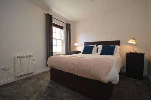 托伯莫里的住宿－Otter Apartment，一间卧室配有一张带蓝色枕头的大床