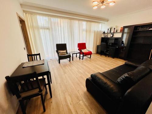 a living room with a couch and chairs and a table at Residential area - quiet place in Brussels