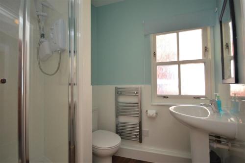 a bathroom with a sink and a toilet and a window at Eagle Ensuite Room in Tobermory