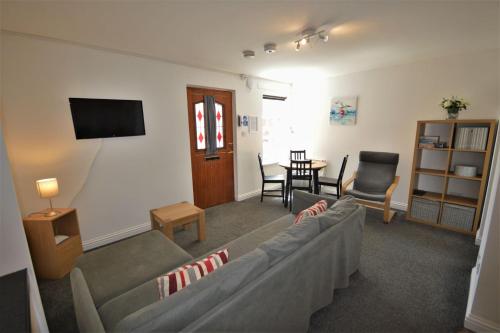 a living room with a couch and a tv at Puffin Apartment in Tobermory