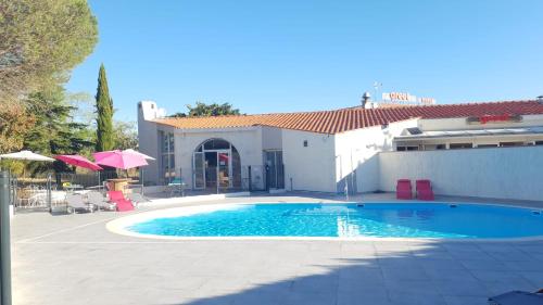 - une piscine en face d'une maison dans l'établissement Greet Hôtel Castres Saix, à Saix