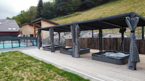 une pergola sur une terrasse à côté d'une piscine dans l'établissement La Ferme de Rochesson, Jacuzzis & Piscine commune, à Rochesson
