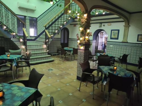 un restaurant vide avec des tables, des chaises et des escaliers dans l'établissement Hostal Restaurante Bar Cafeteria La Melchora, à Posadas
