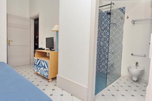 sypialnia z łazienką z umywalką i toaletą w obiekcie Hotel Garden Riviera w mieście Santa Maria di Castellabate