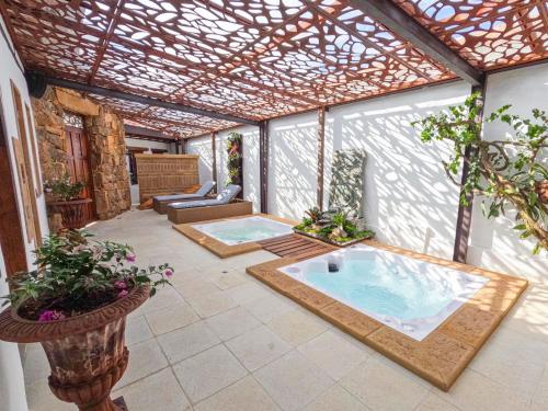 un patio con bañera de hidromasaje y pérgola en Hotel Boutique El Carmel, en Villa de Leyva