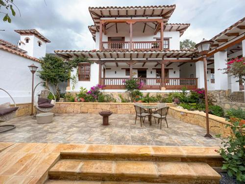 a patio with a table and chairs in front of a house at Hotel Boutique El Carmel in Villa de Leyva