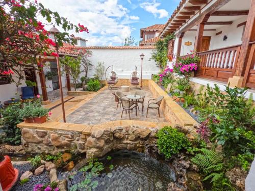 a patio with a table and chairs on a bridge over a pond at Hotel Boutique El Carmel in Villa de Leyva