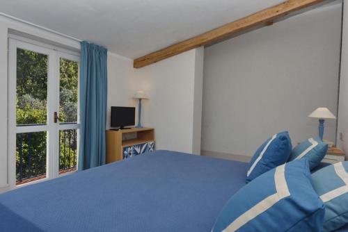 a bedroom with a blue bed and a window at Hotel Garden Riviera in Santa Maria di Castellabate