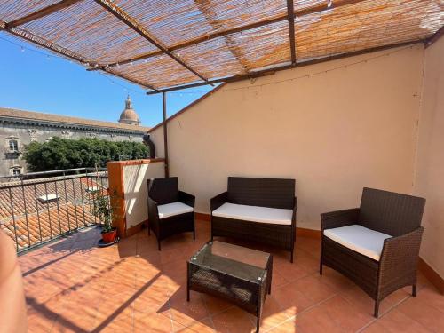un patio con sedie e un tavolo e un balcone di Teatro Greco Suite a Catania