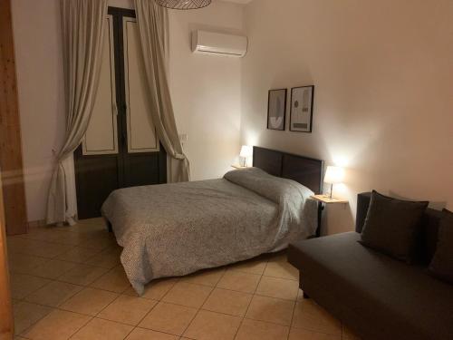 una camera da letto con un letto e un divano di Teatro Greco Suite a Catania