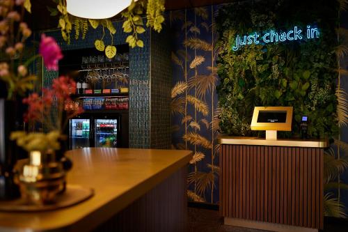 a restaurant with a bar with a desk with a computer on it at Auberge Du Bonheur in Tilburg