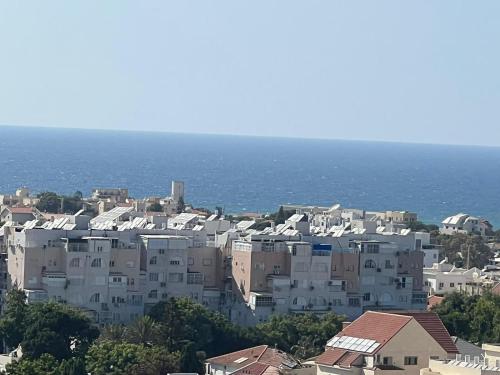 a group of white buildings in front of the ocean at סטודיו חדש ויפה עם נוף לים in Netanya