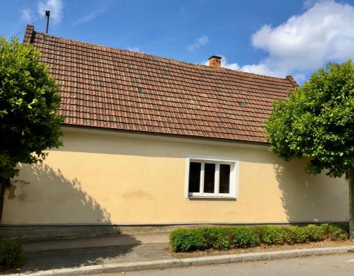 Casa blanca y amarilla con techo rojo en Rodinný domek v centru Plané nad Luž. Jižní Čechy, en Planá nad Lužnicí