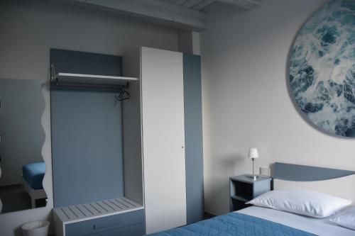 a bedroom with a blue bed and a mirror at Appartamento La Rosa Dei Venti in Civitanova Marche
