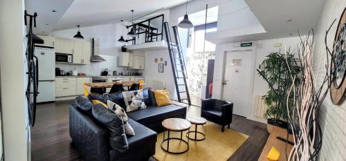 ein Wohnzimmer mit einem blauen Sofa und einer Küche in der Unterkunft Mía Suites II Loft Centro Histórico - PARKING & WIFI FREE in Burgos
