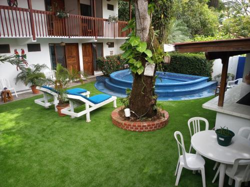 un patio trasero con piscina, mesa y sillas en Hotel Casa del Mar, en Sámara