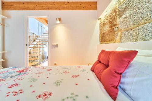 1 dormitorio con 1 cama con almohada roja en La casita de Singulis, en Cangas de Morrazo