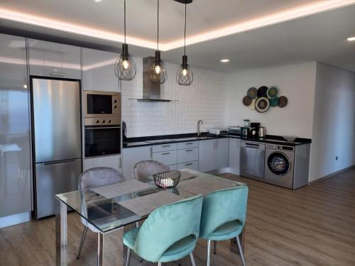 a kitchen with a dining room table and chairs at Apartamento Domingos in Arco da Calheta