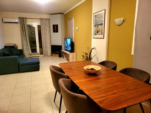 uma sala de estar com uma mesa de madeira e cadeiras em Helios Apartments - Beach of Lachania Rhodes em Lakhania