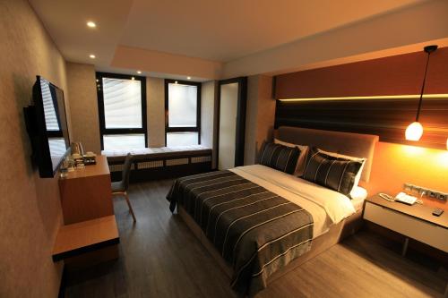 1 dormitorio con 1 cama, escritorio y ventanas en The Black Hotel, en Eskisehir