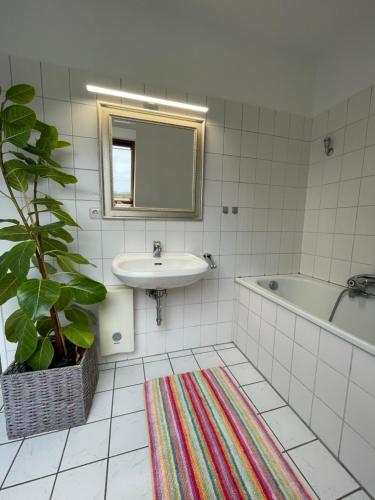 Doppelzimmer في Borgholzhausen: حمام مع حوض وحوض ومرآة