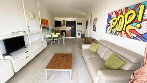 salon z kanapą i telewizorem w obiekcie Apartamento Moradias w mieście Santa Maria