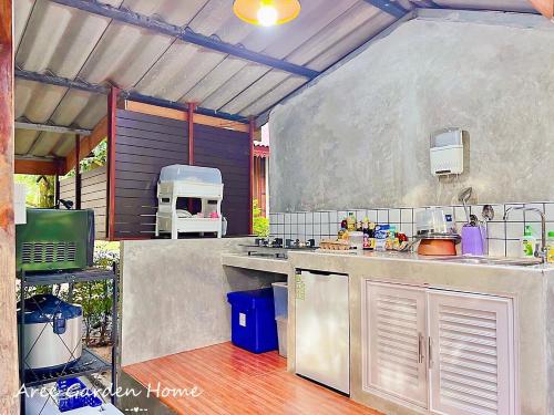 cocina con fregadero y fogones en Aree Garden Home Private Homestay by the Waterfall Chantaburi - บ้านสวนพลิ้วอารี ริมธารน้ำตกพลิ้ว จันทบุรี, 