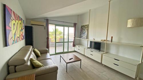 a living room with a couch and a tv at Apartamento Moradias in Santa Maria