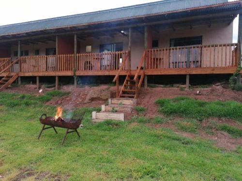 a house with a fire in the yard in front of it at Cango's Rest in Oudtshoorn