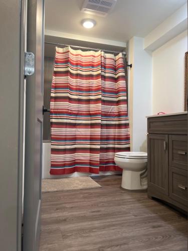 a bathroom with a shower with a striped shower curtain at Tranquil Oasis 2 bedroom Suite with Pool View in Victoria