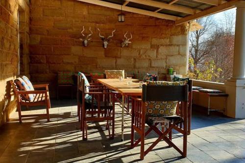 a wooden table and chairs on a patio at House at Glengariff in Underberg