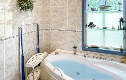 Stunning Home In Gamleby With Kitchen في Gamleby: حوض استحمام في الحمام مع نافذة