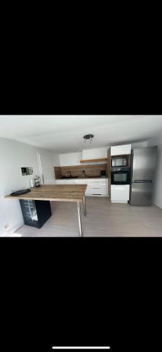 - une cuisine avec une table en bois et une cuisinière dans l'établissement Charmant appartement avec terrasse entre centre-ville et plages de Concarneau, à Concarneau